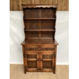 Oak two height dresser with open shelves above, two drawers and two carved panelled doors below, 91c