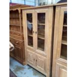 Good quality contemporary limed oak bookcase with adjustable shelves enclosed by two glazed doors, w