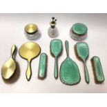 Art Deco silver and yellow guilloché enamel four piece dressing table set and one other