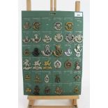 Four boards mounted with British military cap badges, various regiments including Connaught Rangers,