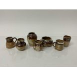 Seven Doulton miniature stoneware items including jugs, tyg, vase, beaker etc all decorated with hun