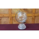 A Waterford Crystal World Globe with cut-glass decoration within chromium support upon a cut-glass c