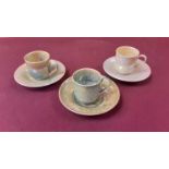 Three Ruskin pottery coffee cans and saucers