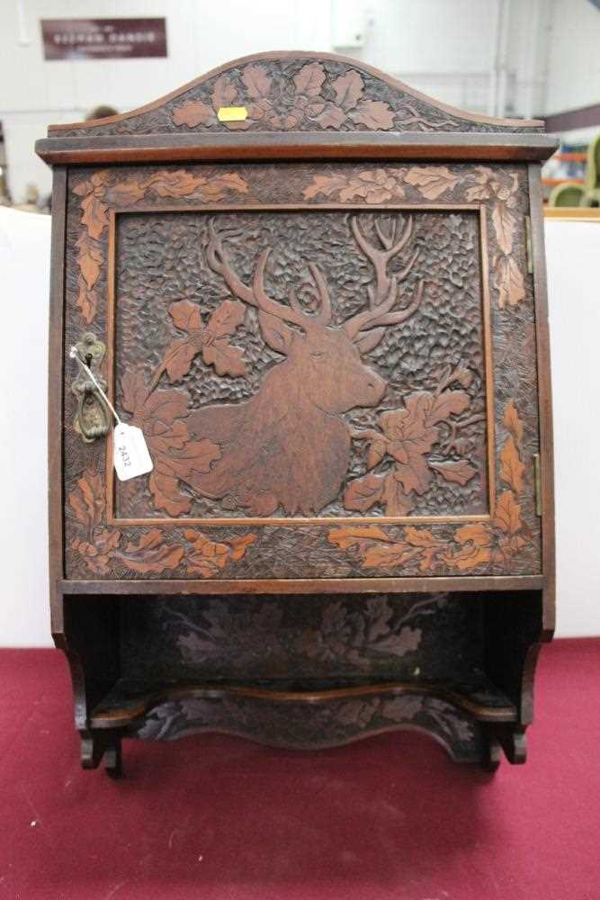 Black Forest type caved hanging cabinet, with figures, foliage and a stag, 61cm high x 44cm across