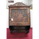 Black Forest type caved hanging cabinet, with figures, foliage and a stag, 61cm high x 44cm across