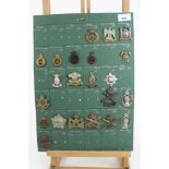 Four boards mounted with British military cap badges, various regiments including Guards Machine Gun