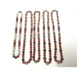 Five Chinese green hard stone and carnelian polished bead necklaces