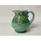 Charlotte Rhead Crown Ducal jug with floral decoration on green ground, signed, 15.5cm high