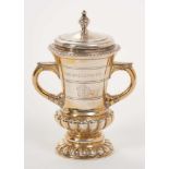 George V silver gilt two handled trophy with embossed reeded borders, engraved Coat of Arms and insc
