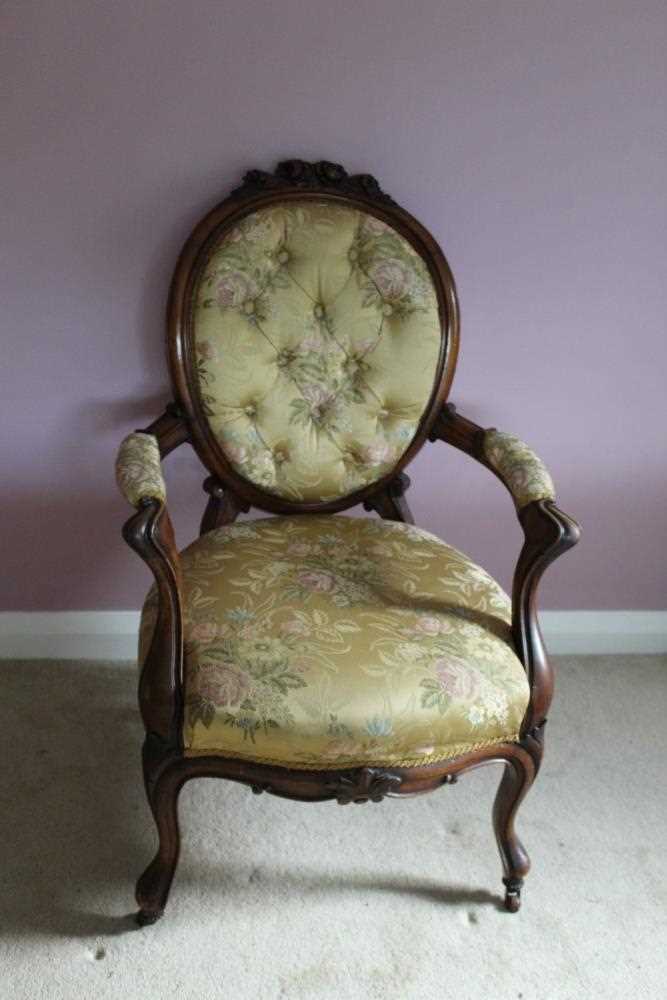 Victorian carved rosewood framed open arm chair with carved floral cresting upholstered in buttoned