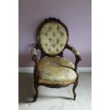 Victorian carved rosewood framed open arm chair with carved floral cresting upholstered in buttoned
