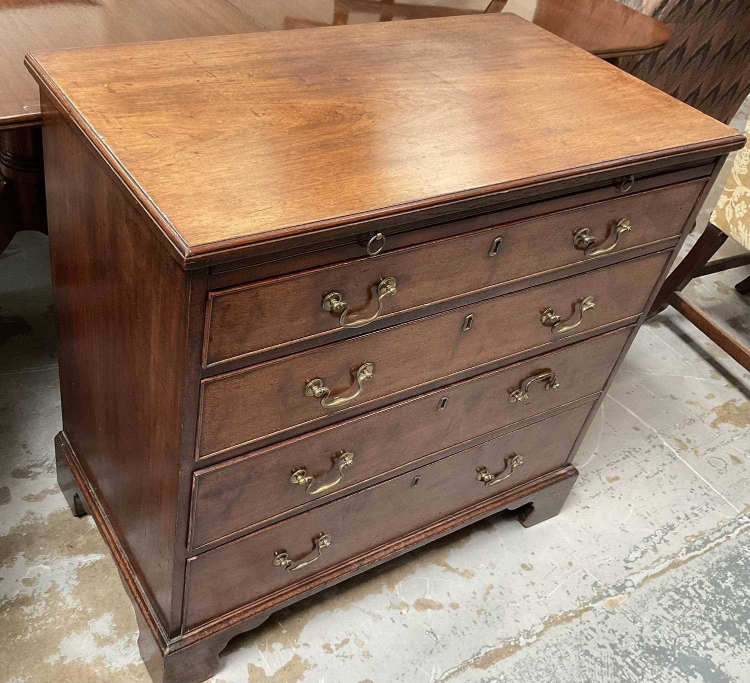 George III mahogany chest of drawers with brushing slide and four long graduated drawers with brass