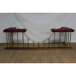 Good antique style brass club fender with maroon leather buttoned seats, on reeded supports
