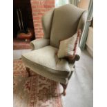 Modern wing back armchair, with chequer upholstery, raised on carved cabriole legs