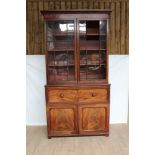 George IV mahogany two height secretaire bookcase, the glazed upper section enclosing three adjustab