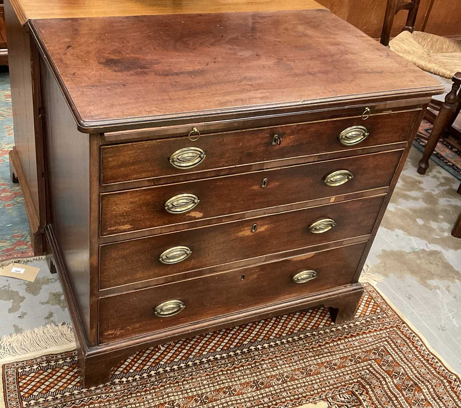 George III mahogany chest of drawers with brushing slide and four long graduated drawers with oval b