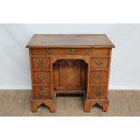 18th century walnut kneehole desk with an arrangement of seven drawers and central sliding cupboard,