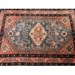 Two Persian design rugs, the first with radiating medallion on sky blue ground, signature panel, tas