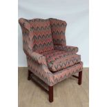 Georgian-style wing armchair upholstered in brightly coloured fabric, with loose cushion