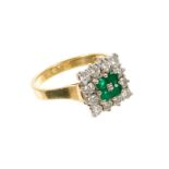 Emerald and diamond cluster ring with a square cluster of four emeralds surrounded by twelve brillia