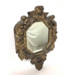 Continental Baroque carved giltwood wall mirror, with octagonal plate within heavy mask and scroll c
