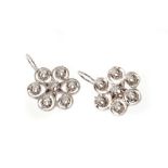 Pair of diamond flower head cluster earrings, each with seven brilliant cut diamonds in 14k white go