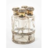 Late 19th century French silver mounted perfume set of four fitted bottles in a silver stand.