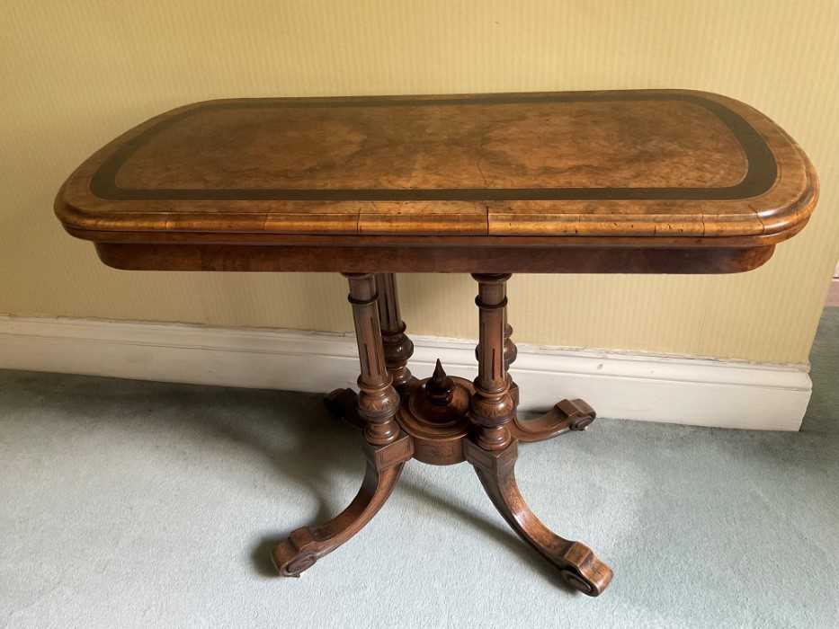 Victorian figured walnut and ebonised banded card table, of rounded rectangular form on fluted colum