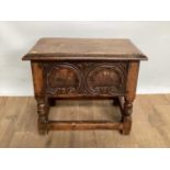 Antique-style oak coffin stool with rising lid, carved front and turned supports joined by stretcher