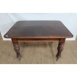 Victorian mahogany rectangular dining table with turned and faceted legs on brass capped ceramic cas