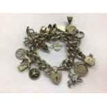Silver charm bracelet with padlock clasp and various silver/white metal novelty charms