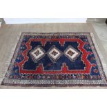 Eastern rug with geometric decoration and three central medallions on red, blue and cream ground, 79