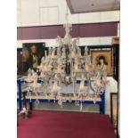 Large glass chandelier, with twelve scrolling candle arms issuing thirty dished lights with prismati
