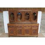Highly ornate Anglo-Indian carved hardwood suite of dining furniture, comprising rounded rectangular