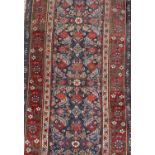 Antique Hamadan runner with all over floral motif in meander boarders on red and blue ground. 500cm