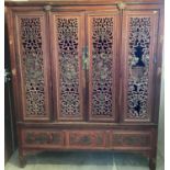 Antique Chinese cupboard with drawers and shelves enclosed by finely carved and pierced doors decora