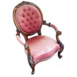 Victorian carved walnut and button upholstered open armchair.