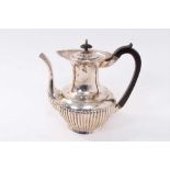 Early George V silver teapot of fluted baluster form, with flared rim, ebony handle