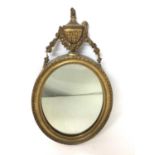 Regency gilt oval wall mirror with urn cresting