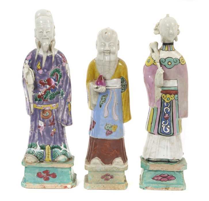 Three Chinese porcelain figures of immortals, Qianlong period, each polychrome decorated and shown s