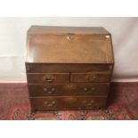 George III oak bureau with fitted interior with secret compartments and writing well, two short and