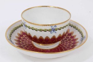 A Chelsea-Derby tea bowl and saucer, circa 1770, pineapple-moulded and painted with floral sprays an