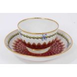 A Chelsea-Derby tea bowl and saucer, circa 1770, pineapple-moulded and painted with floral sprays an