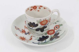 A Worcester 'Kempthorne' coffee cup and saucer, circa 1770, polychrome painted with stylised flower