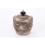 George V silver tea caddy of oval form with fluted decoration, hinged domed cover, with turned wood