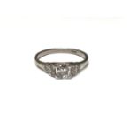 Art Deco diamond ring with a brilliant cut diamond flanked by stepped diamond shoulders on 18ct whit