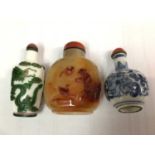 Three Chinese snuff bottles, including porcelain, glass and stone