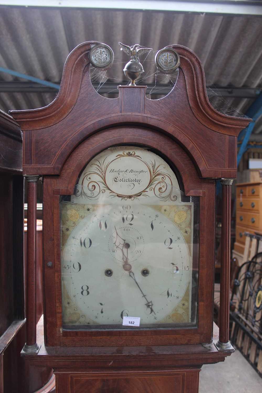 Georgian 8 day long case clock by Hedge & Bannister of Colchester with painted dial in inlaid oak