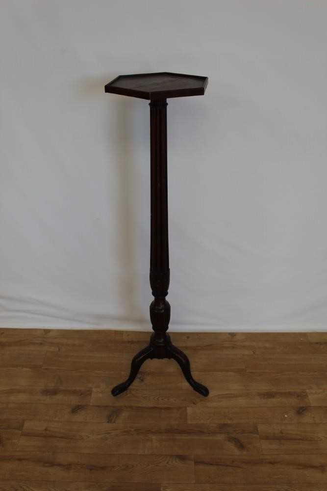 Late Victorian mahogany torchere with hexagonal top on reeded column and three hipped splayed legs,