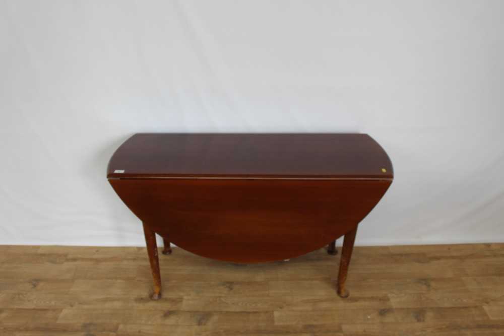 Mahogany oval drop leaf table on turned legs, opening to 128cm x 122cm